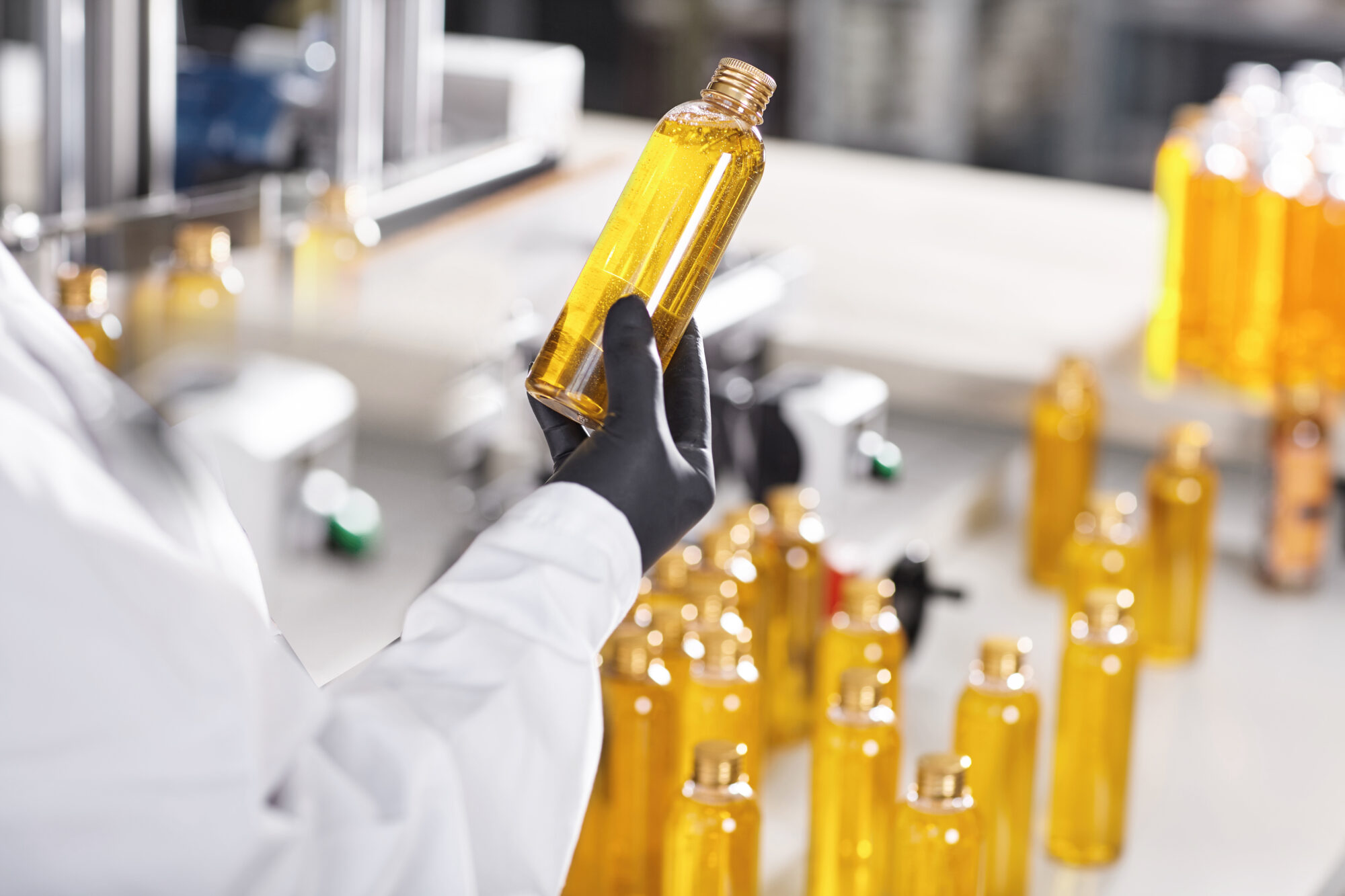 Manufacturing concept. Factory worker holding two glass bottles